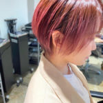 明るいピンク色のつやつやボブヘアの女性