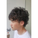 パーマヘアの男性の横顔