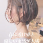 優しい髪色の束感のあるショートヘアの女性