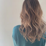 毛先にかけて明るい茶色のグラデーションになったロングヘアの女性