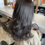 暗髪パーマのロングヘアの女性