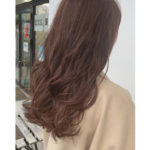 ピンクブラウンの髪色のロングヘアの女性